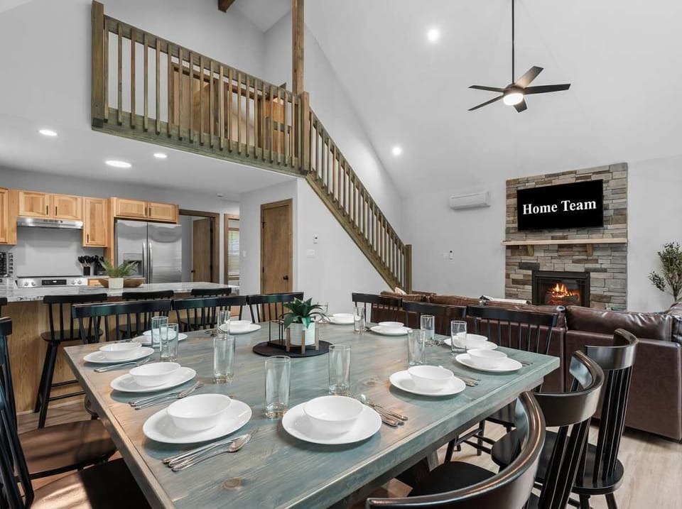 Gather the whole crew around this stunning farmhouse dining table, with the kitchen steps away, a cozy fireplace glowing in the background, and enough space for everyone to eat, laugh, and linger.