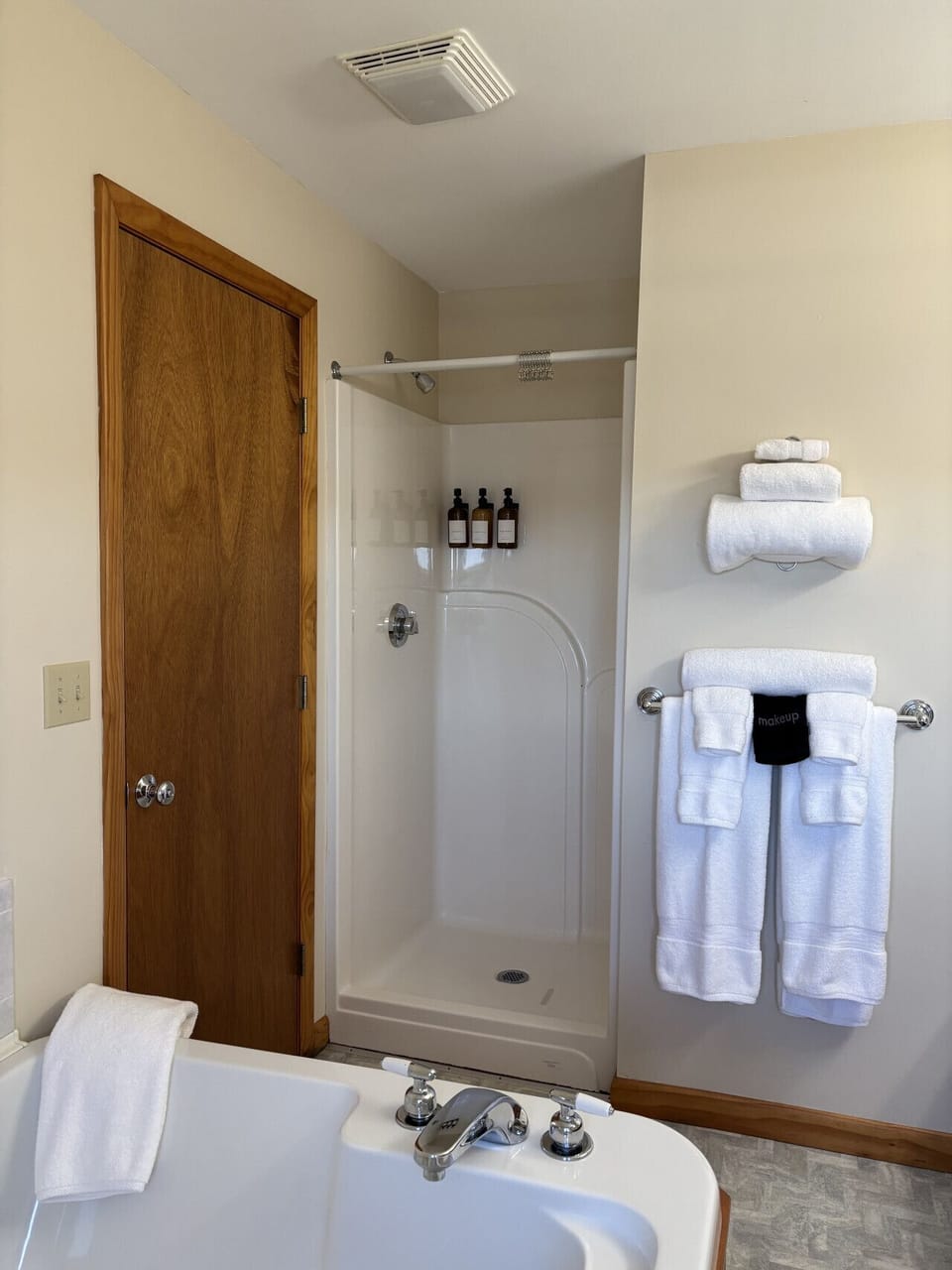 Clean modern bathroom with walk-in shower, soaking tub, and fresh luxury touches.