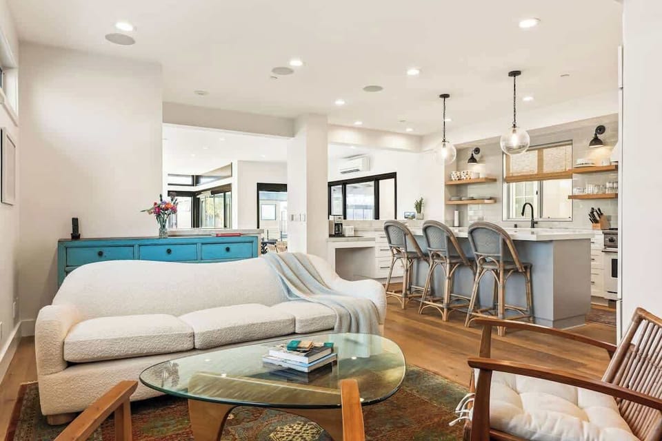 The living room opens seamlessly into the kitchen, creating a bright, welcoming space for gathering, conversation, and shared meals.