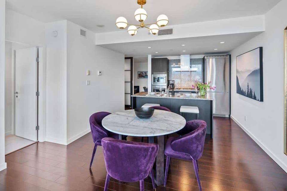 Dining table with four purple velvet chairs and breakfast bar for two.