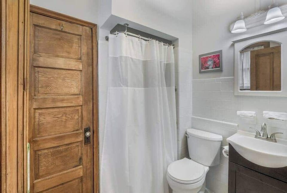 Full bathroom with vanity and shower, offering a clean and practical layout.