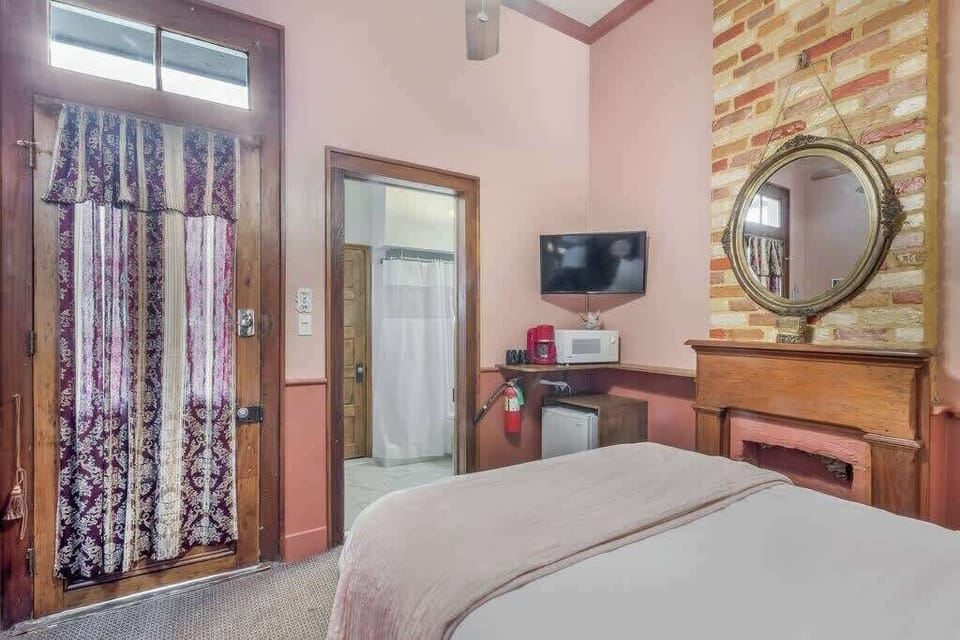 Bedroom with natural light, brick details, and cozy furnishings for a comfortable stay.