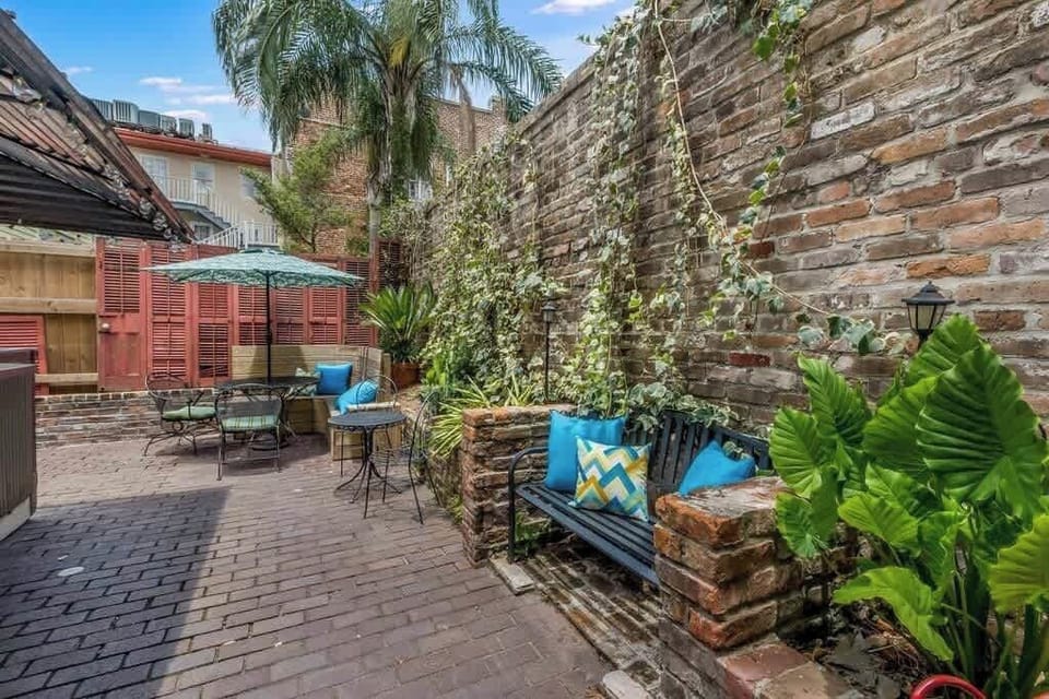 Lush courtyard walkway with greenery and seating, creating a peaceful outdoor retreat.