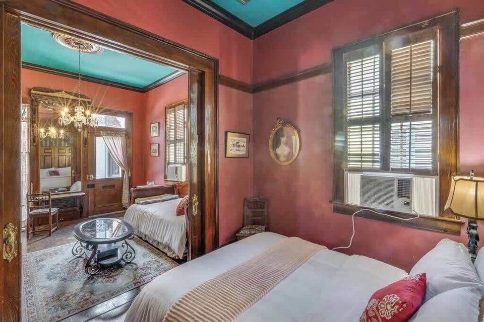Another view of the bedroom highlighting bold colors, high ceilings, and timeless character.