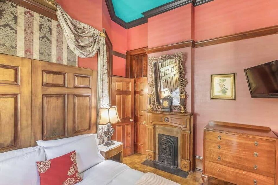 Bedroom with wood-paneled accents and vintage touches, creating a cozy and distinctive space.