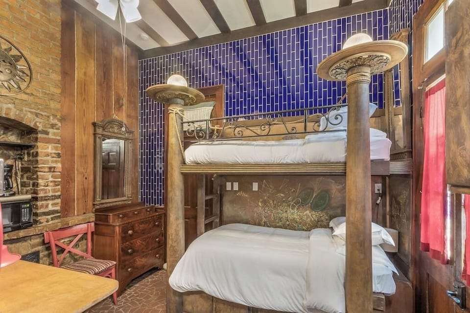 Unique bedroom with bold design, exposed brick, and rustic wood accents for a one-of-a-kind stay.
