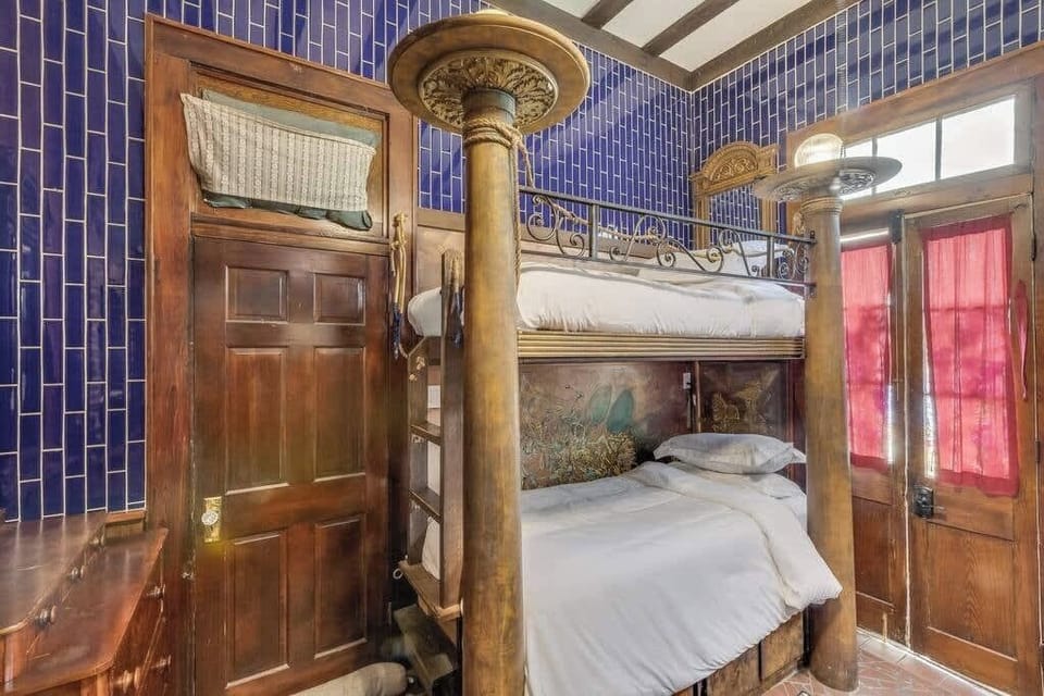 Another view of the bedroom highlighting colorful tilework, wood details, and cozy sleeping space.