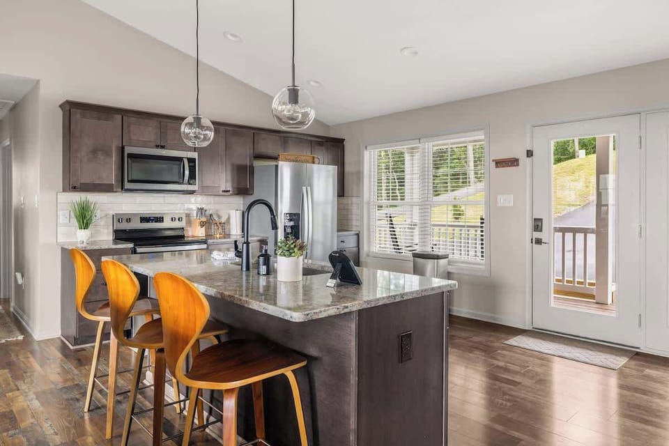 Bright open kitchen with island, stainless appliances, and seating for four