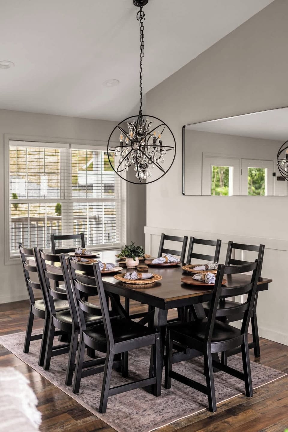 Dining for eight under an iron orb chandelier