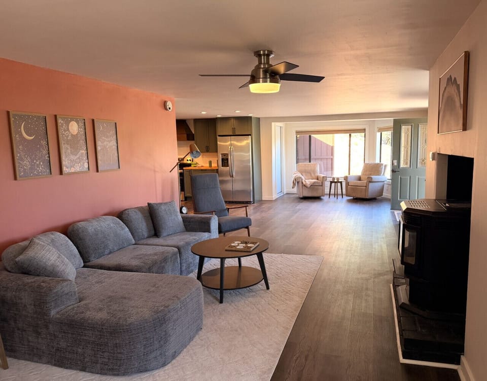 Inviting open-concept living space , ceiling fan, cozy sectional sofa, and charming barn door details.