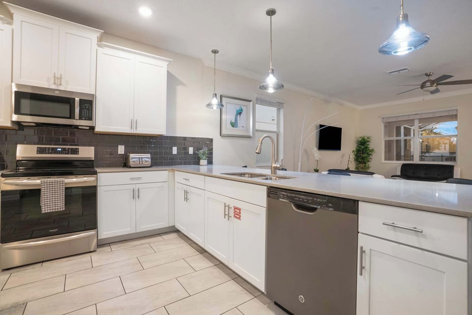 Modern kitchen with stainless steel appliances and a spacious island for cooking and dining.