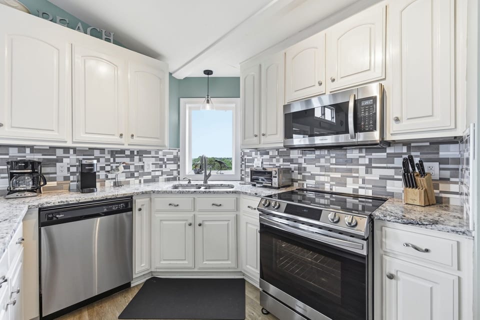 Granite countertops, white cabinetry and updated appliances create a fresh, airy feel. Both single serve and traditional drip pot are provided