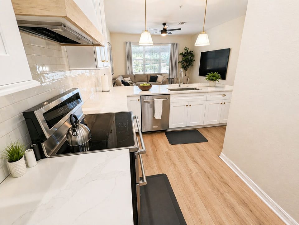 Bright and modern kitchen with sleek countertops, stainless steel appliances, and plenty of prep space. Open layout flows into the living area, making it easy to cook, dine, and stay connected with guests.