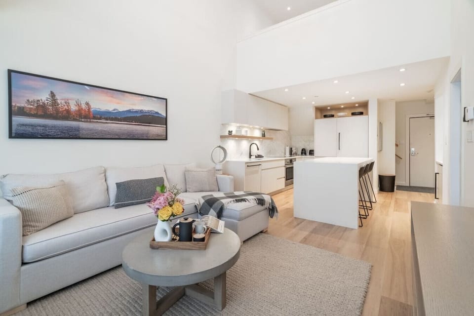 Experience a spacious living room seamlessly connected to an open-plan kitchen and dining area.
