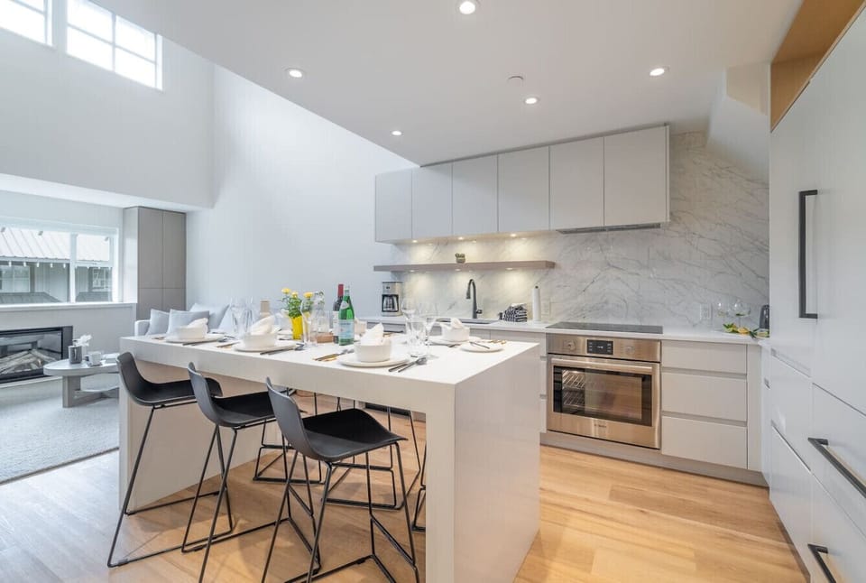 Built-in fridge and freezer complemented by a stainless steel convection oven featuring a ceramic cooktop.