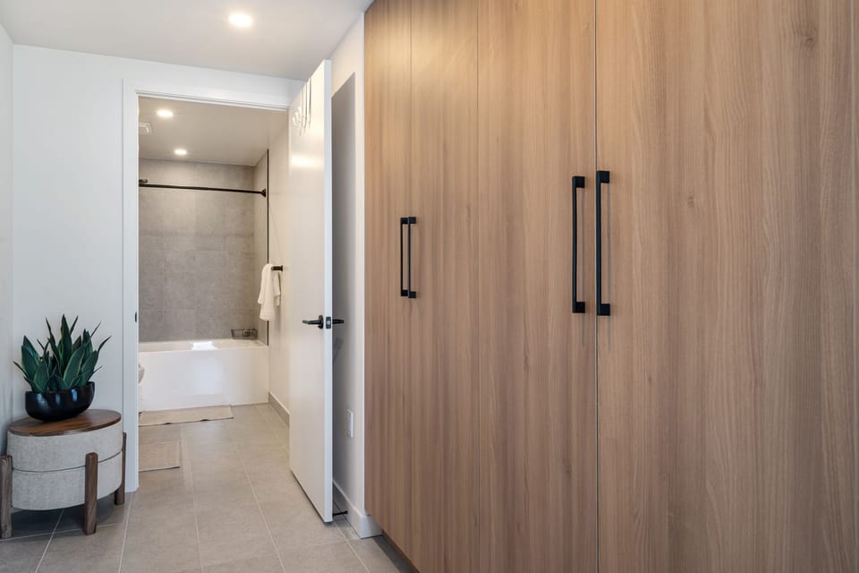 Bedroom entry with warm wood closet space and direct bathroom access.