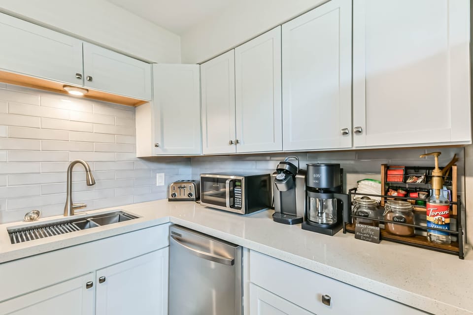 Fully equipped kitchen with stainless steel appliances, sleek quartz counters, and everything you need to cook and dine in comfort.