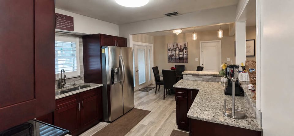 Fully-Equipped. Prepare delicious meals in this sleek, modern kitchen featuring high-end stainless steel appliances, ample granite counter space, and all the essentials. The open layout makes it easy to stay connected with the group while cooking.