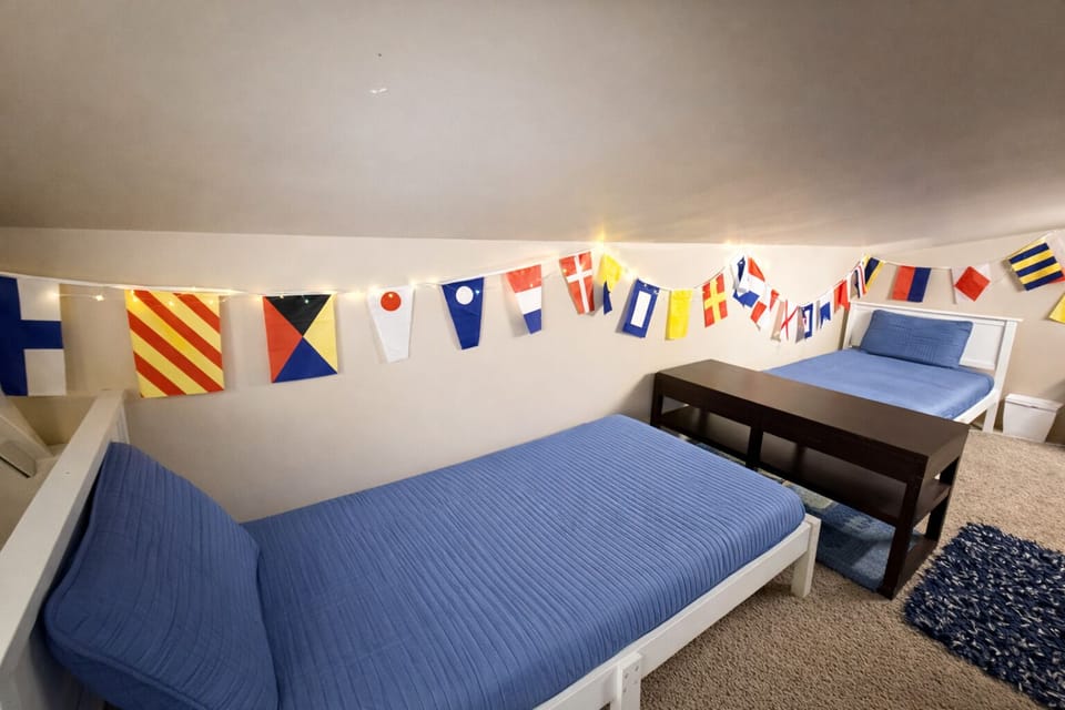 Fun loft retreat with twin beds, colorful maritime accents, and tucked-away comfort for a memorable stay.