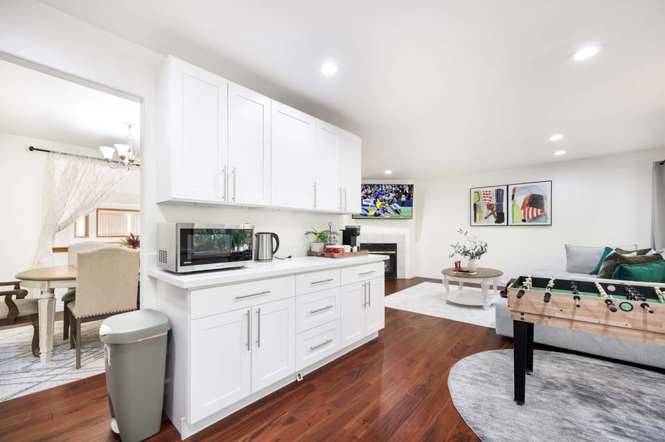 Cook, relax, and play in this open space—white kitchen, cozy living, and a foosball table for endless fun.