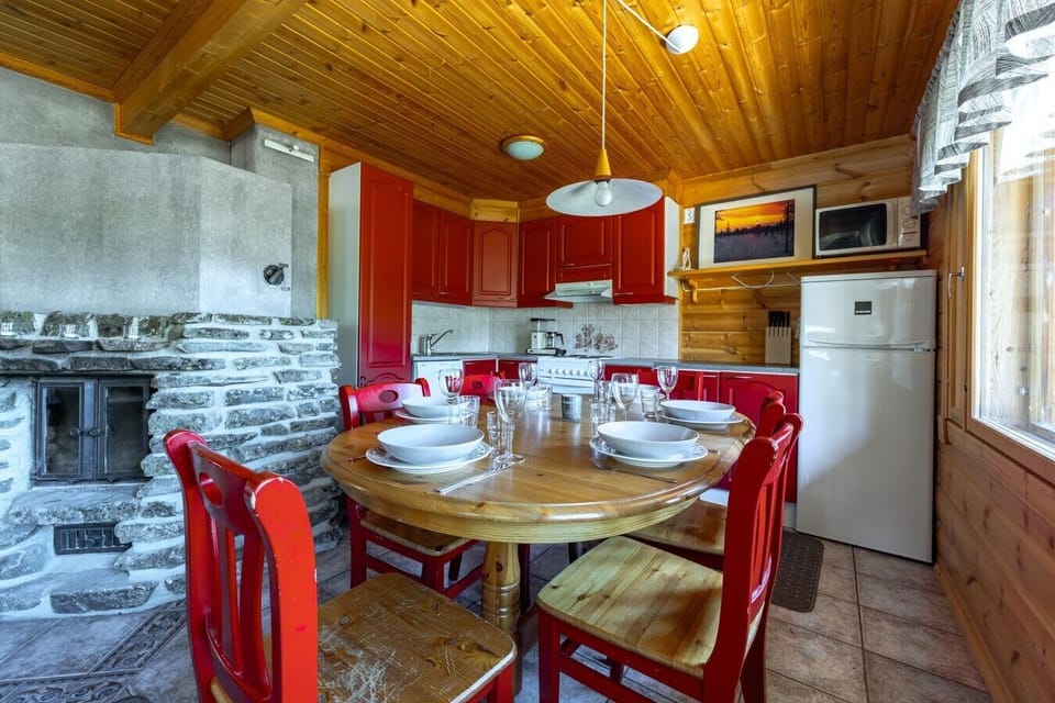 Gather your entire group for a shared meal around the spacious dining table, conveniently located right next to the fully equipped kitchen. The adjacent stone fireplace provides a warm, inviting ambiance while you dine.