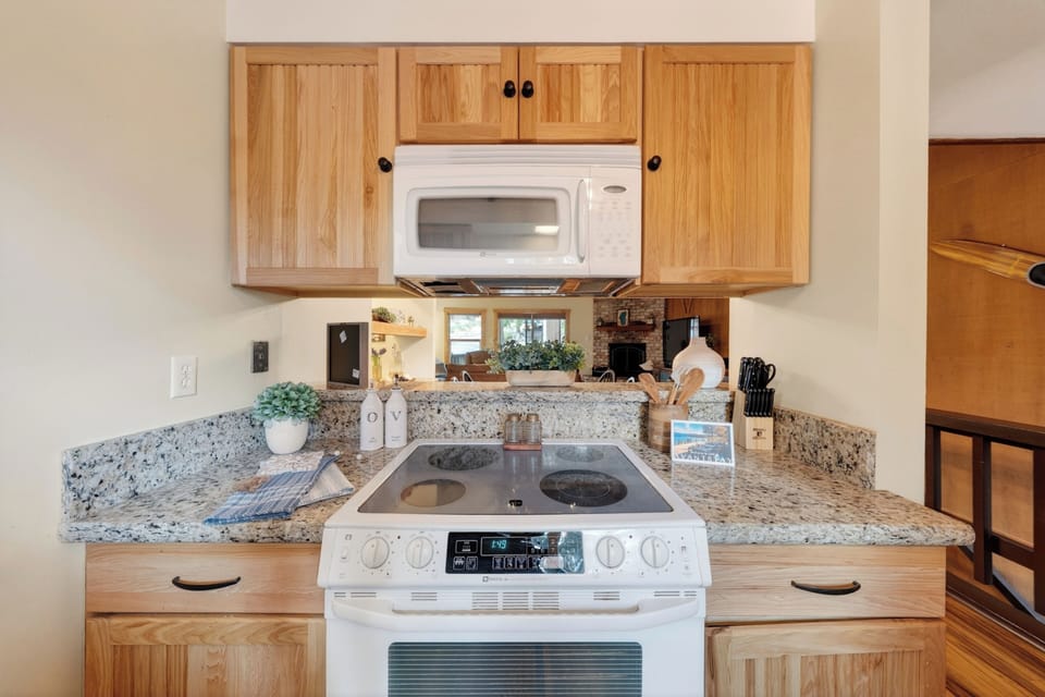 Bright kitchen with granite countertops, coffee station, and in-unit washer/dryer.