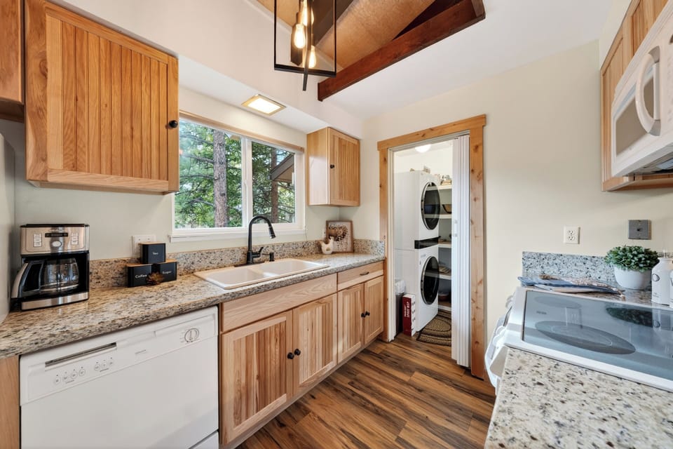 Bright kitchen with granite countertops, coffee station, and in-unit washer/dryer.