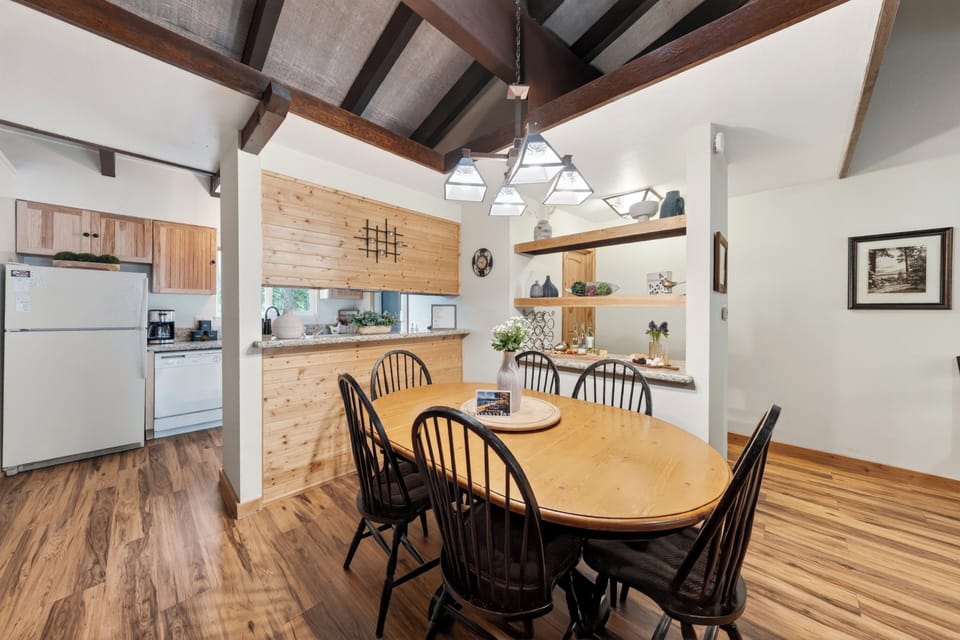 Warm, open dining area with vaulted wood-beam ceilings and easy kitchen access.