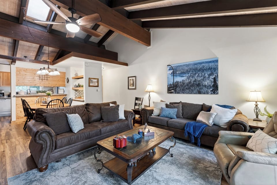 Spacious living area with vaulted ceilings, cozy seating, and an open flow to dining and kitchen.