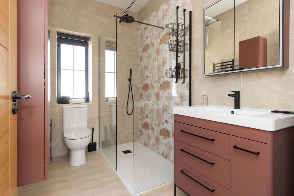 Refresh in a modern ensuite bathroom with walk-in shower, warm tones, and calm Sussex lodge comfort.