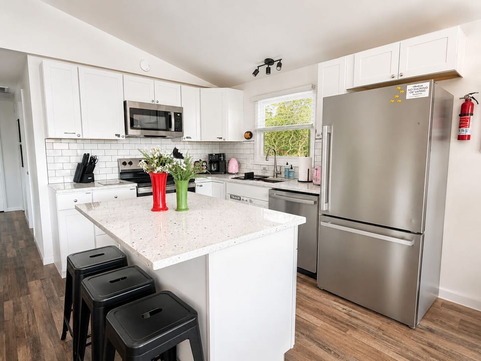 Fully updated kitchen with full sized refrigerator, dishwasher, microwave, and oven with electric cooktop.