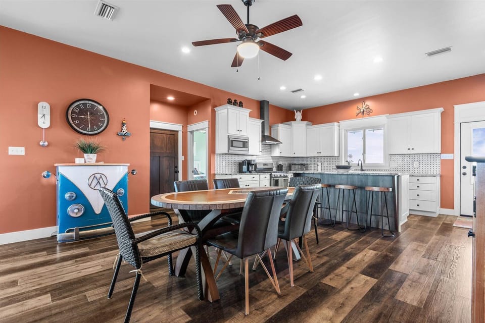 Step into your spacious kitchen and dining area where warm coral walls create a cheerful atmosphere for cooking and gathering together.