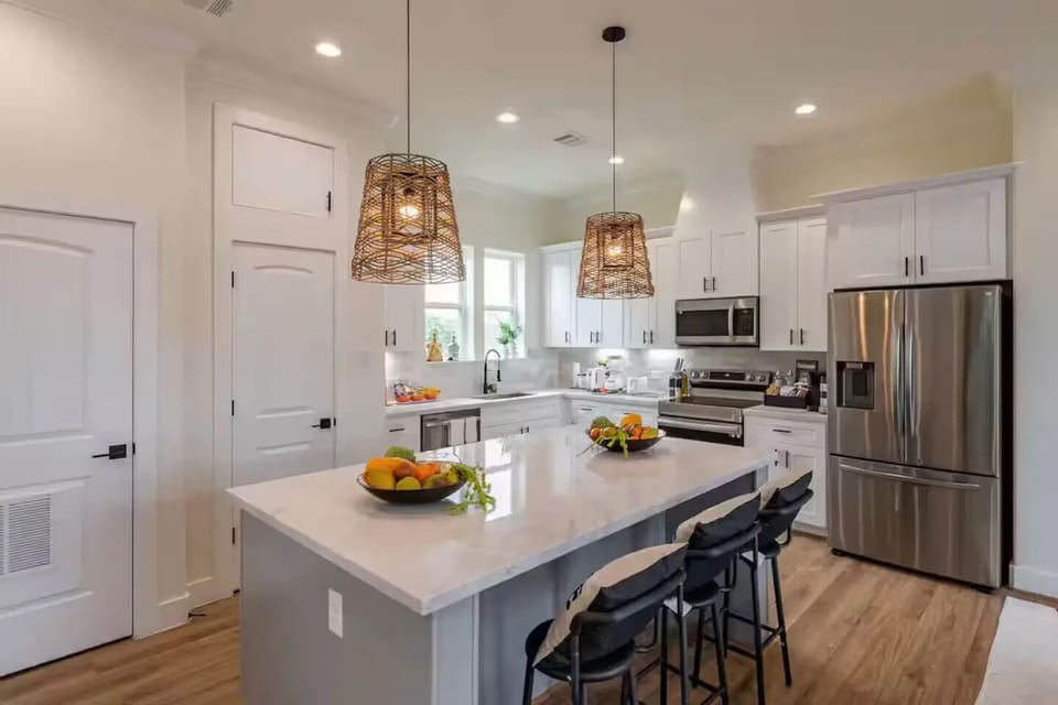 A perfect kitchen setup with comfortable bar stools and modern appliances.