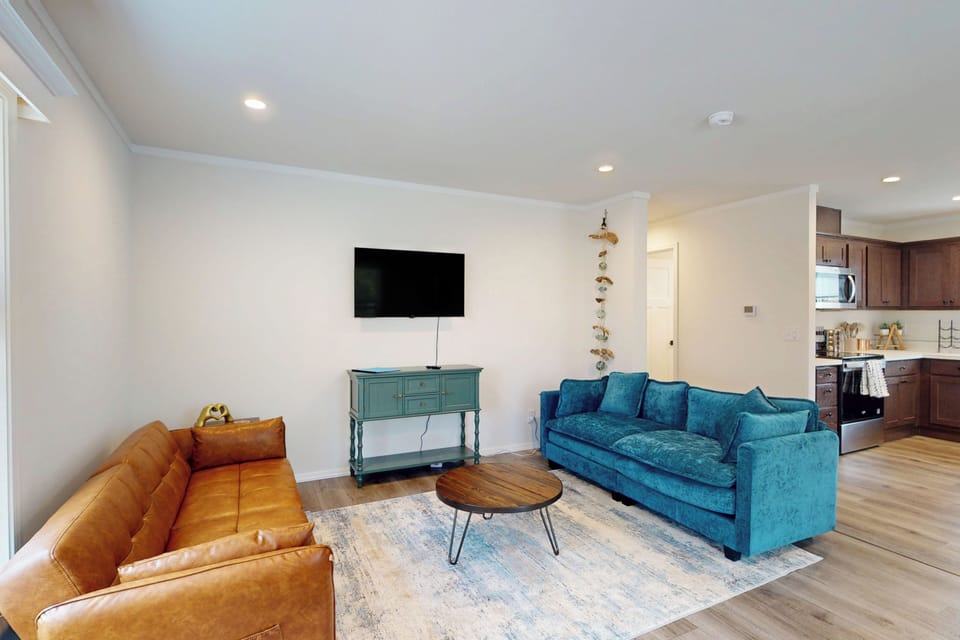 Bright living room with cozy seating and wall-mounted TV