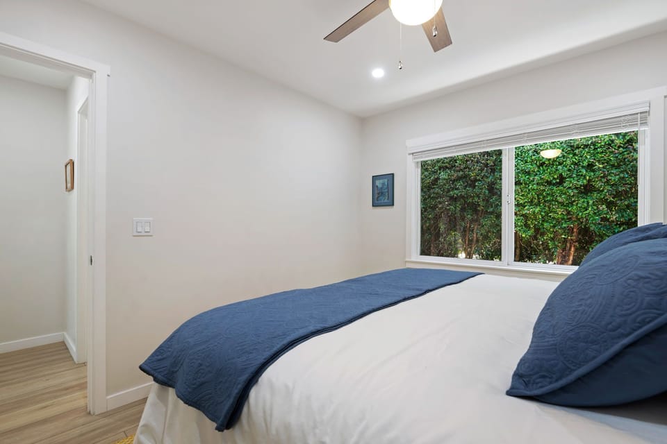 Drift off in this peaceful bedroom featuring crisp linens and garden views that invite natural light into your serene retreat.
