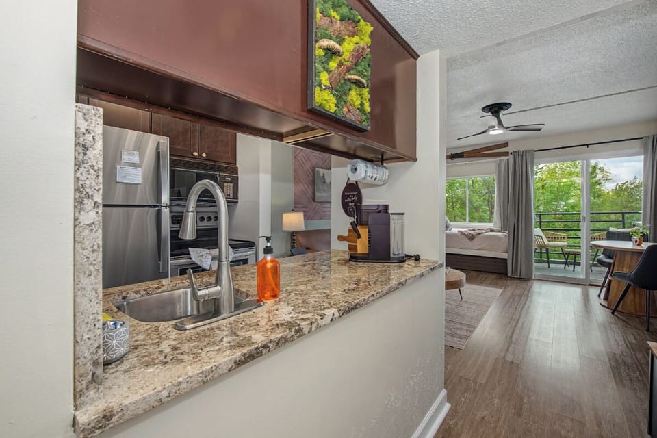 Your open-concept space blends style and comfort, featuring a fully equipped kitchen, cozy sleeping area, and private balcony overlooking lush greenery for peaceful mornings.