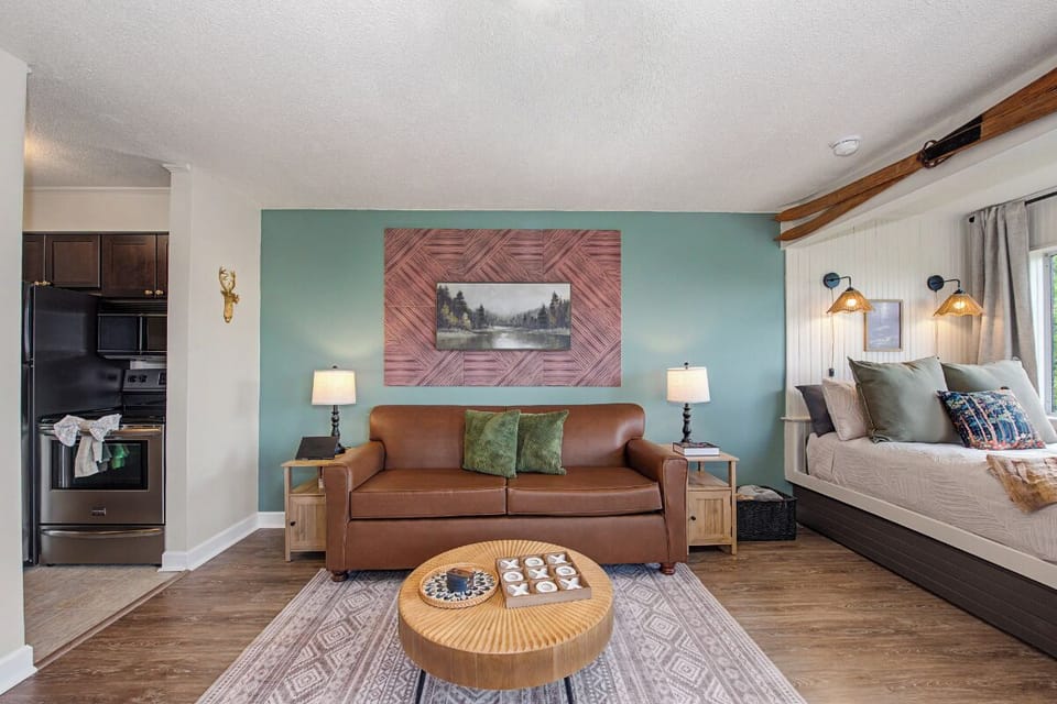 Settle into your cozy studio where a plush leather sofa and welcoming bed await. Natural wood accents and soothing walls create a peaceful retreat after a day exploring the mountains.