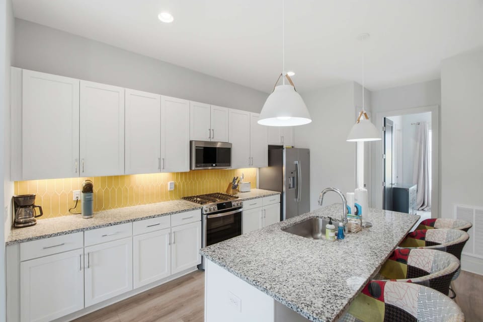 Sleek granite counters and vibrant accents make cooking a joy in this modern space!