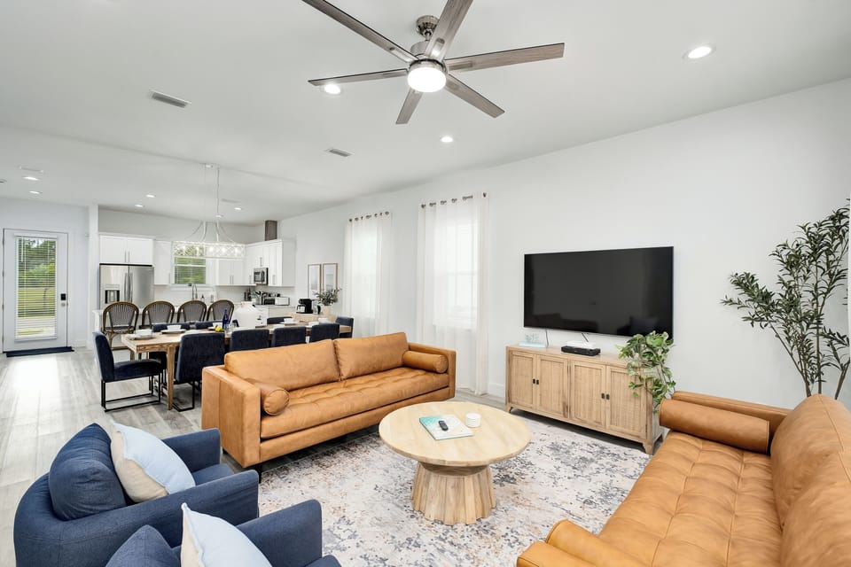 Sink into plush seating and unwind in your light-filled living space, complete with a smart TV, stylish furnishings, and an open flow into the dining and kitchen areas.