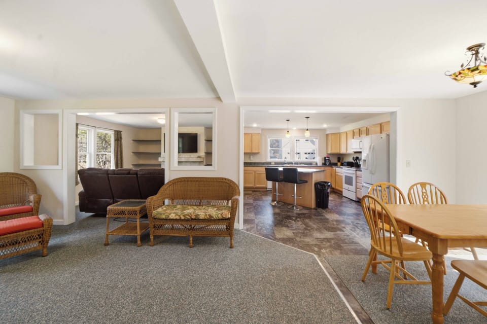 Relax in your spacious open-concept living area where wicker seating flows seamlessly into a fully-equipped kitchen, perfect for memorable meals together.