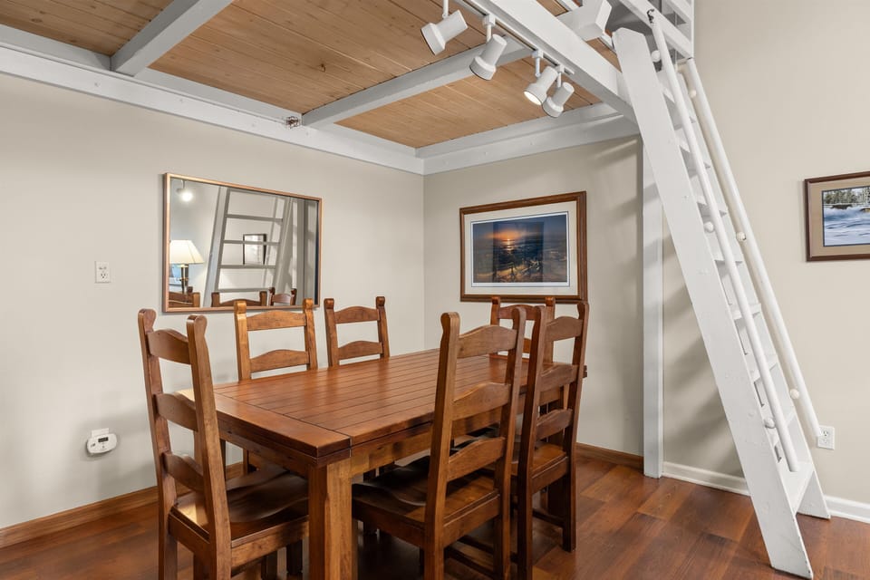 Gather around this beautiful wooden dining table where your group can share meals under stunning exposed beam ceilings with warm wood accents.