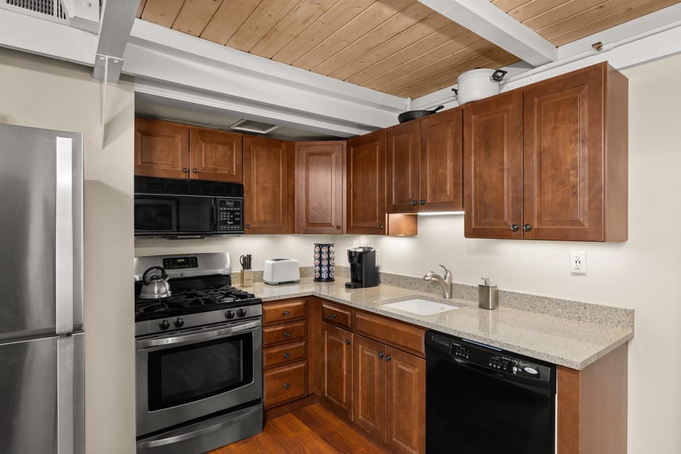 Your fully equipped kitchen features warm wood cabinets, granite counters, and modern appliances for preparing memorable meals during your stay.