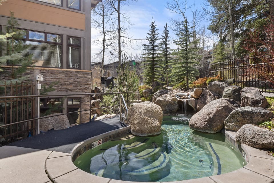 Soak your worries away in this natural stone hot tub, surrounded by towering pines and mountain views.