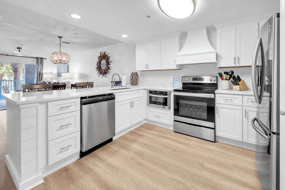 Your culinary dreams come alive in this stunning chef's kitchen featuring gleaming white cabinetry, granite countertops, and premium stainless steel appliances.