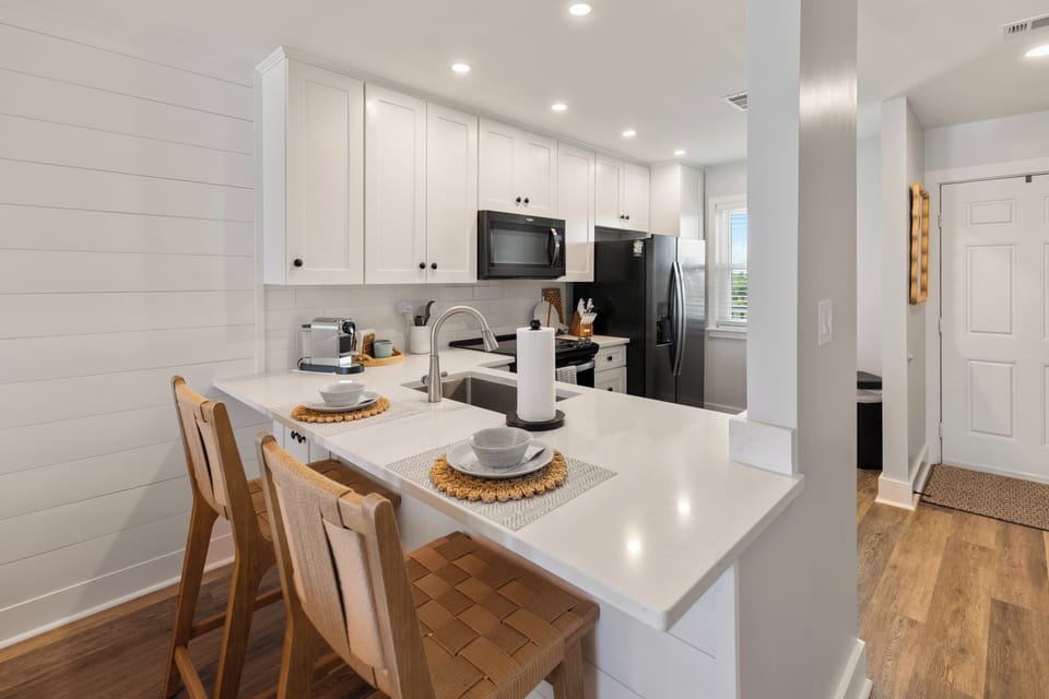 Your bright, modern kitchen features white quartz countertops, stainless steel appliances, and a convenient breakfast bar where you can start each morning.
