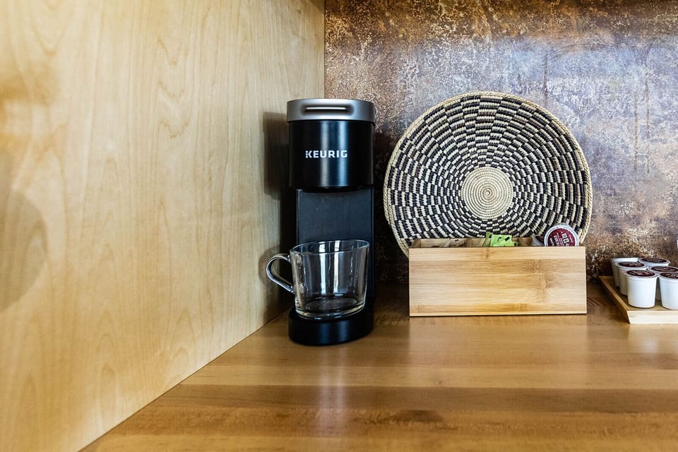 Cozy in-room coffee station with Keurig and complimentary drink essentials