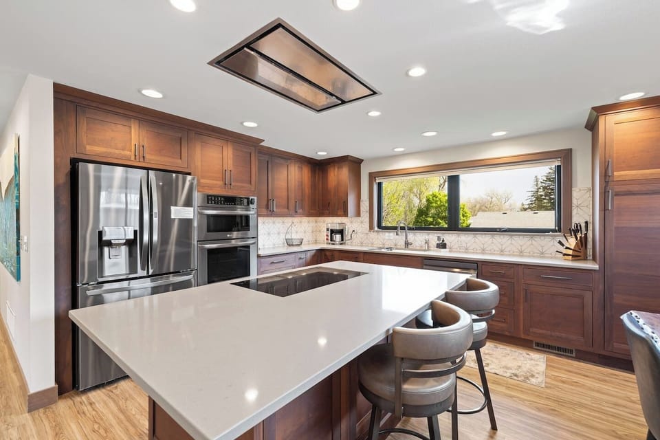 A beautifully designed kitchen featuring rich wood cabinetry and a spacious white island, offering both functionality and an ideal setting for entertaining.