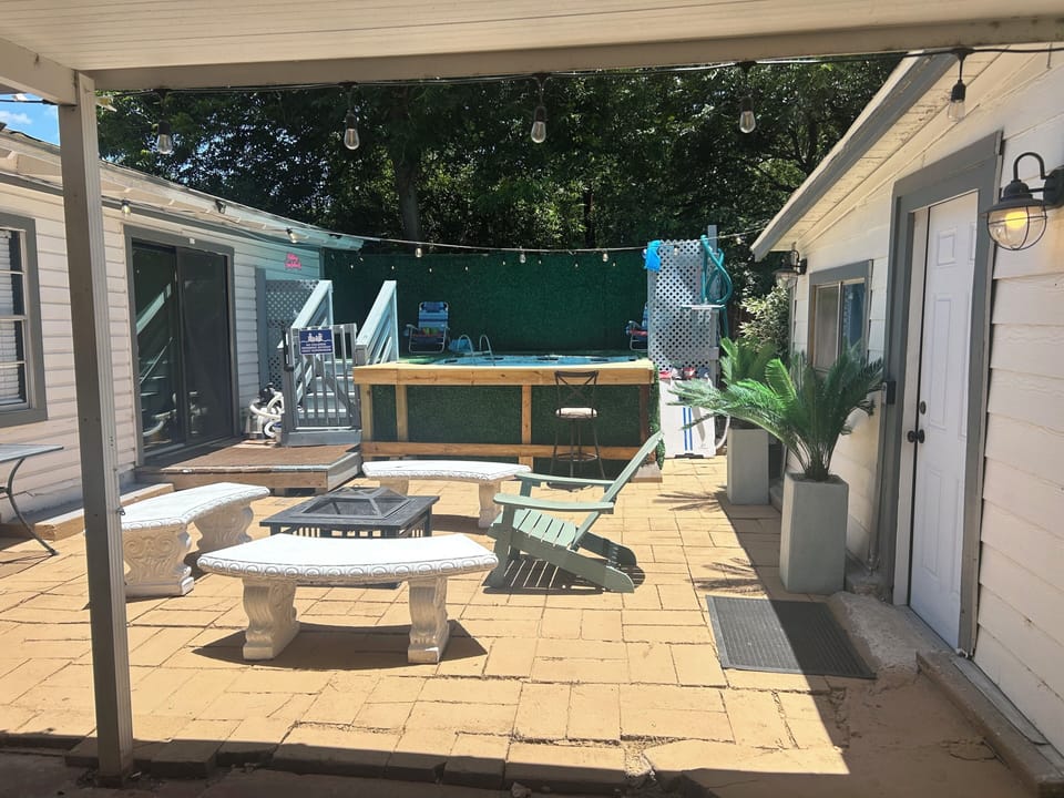 Private patio with fire pit, string lights, and above-ground pool