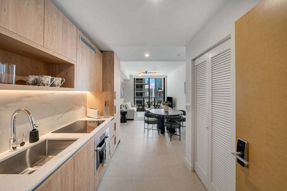 Sleek kitchenette with warm wood finishes and built-in appliances.