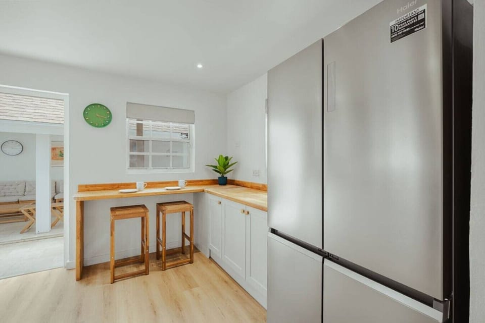 Spacious kitchen setup with a full-size refrigerator and breakfast seating—ideal for storing groceries, preparing meals, and enjoying a quiet start to the day.